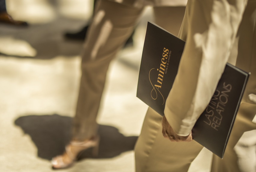 Detalj poslovnog eventa s Aminess brošurama u rukama sudionika.