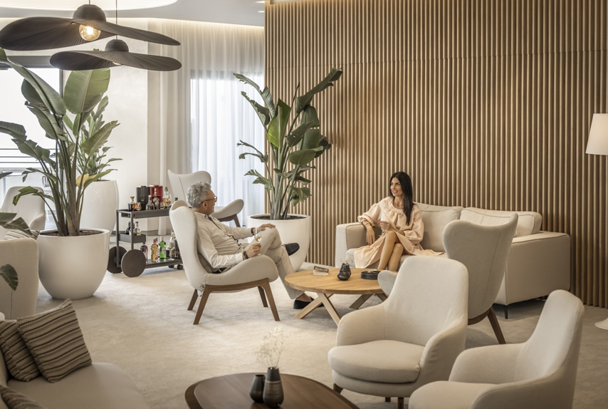 Razgovor gostiju u modernom hotelskom loungeu s dizajnerskim namještajem.