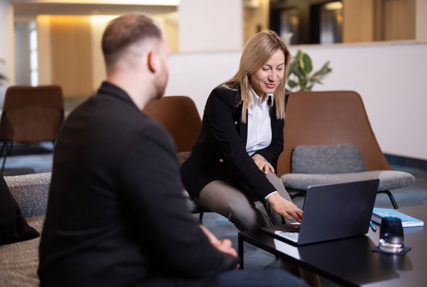 Tim Aminess Hospitality Groupa na internom sastanku u modernom loungeu uz laptop.