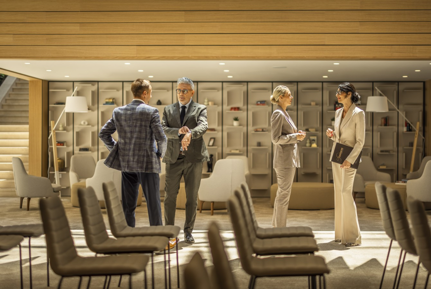 Networking i razmjena ideja tijekom poslovnog događaja u hotelskom prostoru.