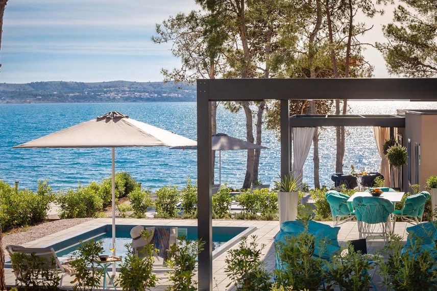 Pogled na kuću za odmor Holiday Home s bazenom i otvorenim suncobranom uz more u Aminess Style Camping Avalona resortu.