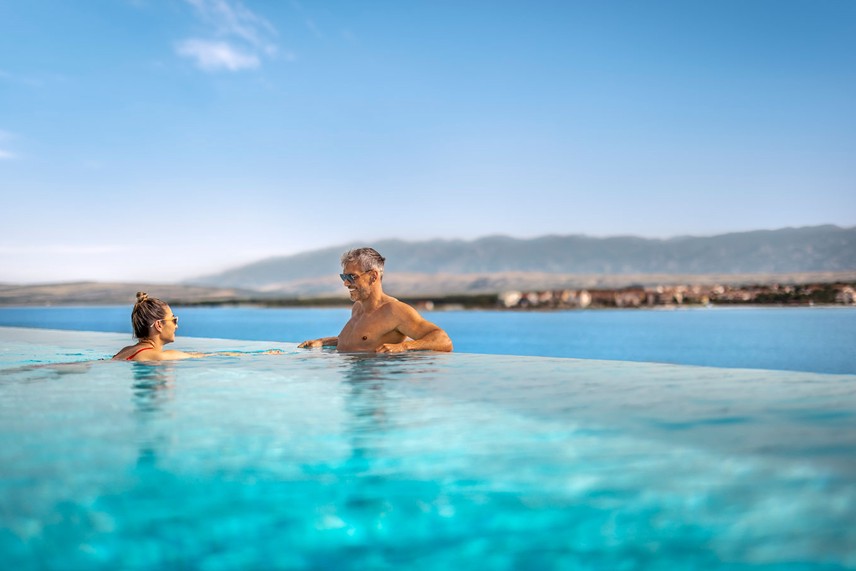 Cople swimming in the relaxing pool with sea view at Aminess Style Camping Avalona resort.