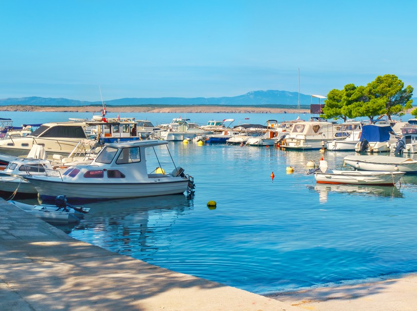 Marina s brodovima privezanim uz mirnu plažu pod vedrim nebom u Crikvenici.