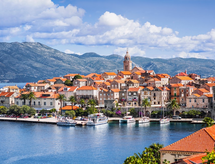 Aerial view of the city of Korcula with blue sea and mountains in the background