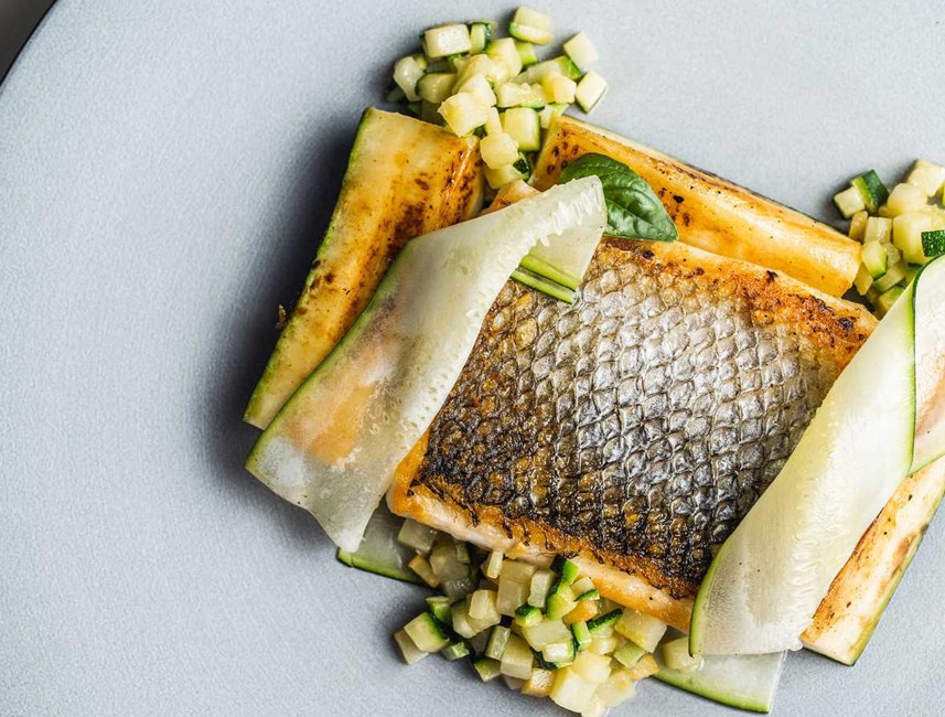 Gourmet grilled fish dish with fresh vegetables and garnishes, served on a plate in Novi Vinodolski, Croatia