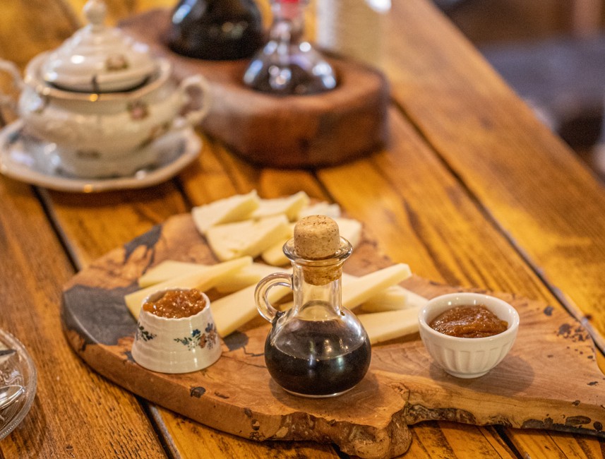 A wooden table with traditional Brač Island cheese and a bottle of olive oil, showcasing local flavors and Mediterranean gastronomy.
