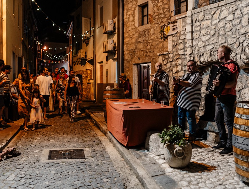 A charming old-town street event in Novi Vinodolski, featuring rustic decorations and an intimate setting.