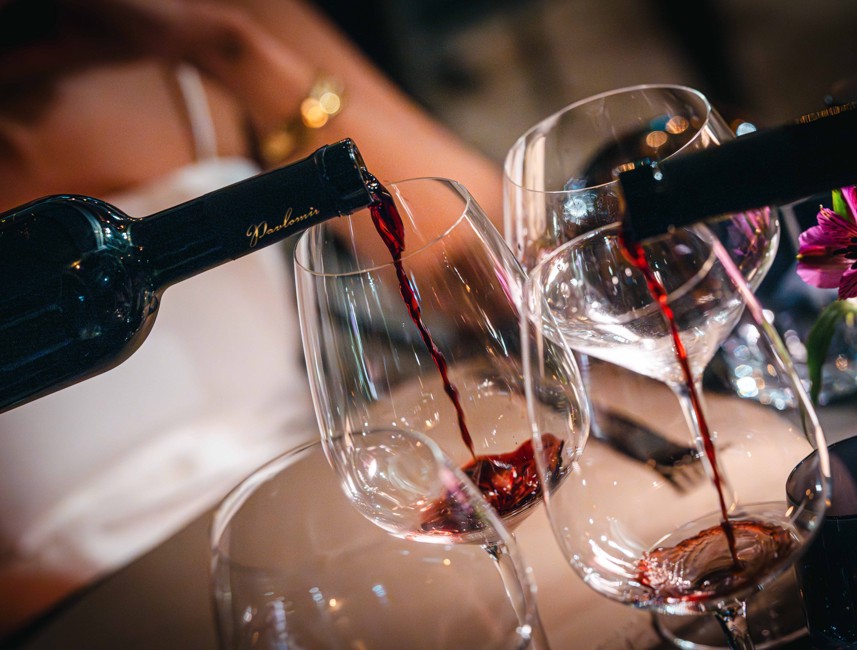 Authentic wine dining experience with red wine being poured into glasses in Novi Vinodolski, Croatia.