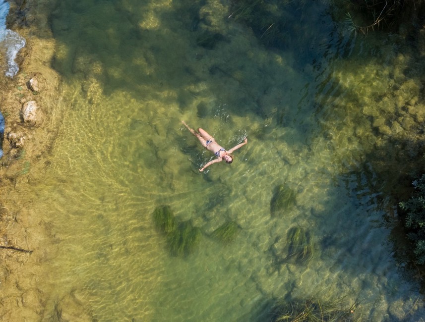 Zwemmen in de kristalheldere rivier Mreznica omringd door natuur