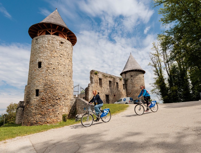 Fietsers rijden langs een historisch kasteel midden in een mooi landschap