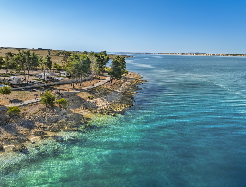 Uitzicht op de kust met helderblauwe zee en fietspad bij Aminess Style Camping Avalona Resort.