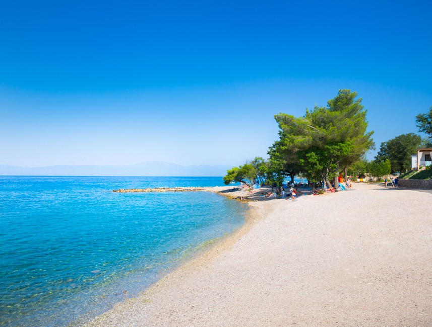 Ein ruhiger Strandplatz mit kristallklarem Wasser in der Nähe des Veya Maradiso Hotels von Aminess.