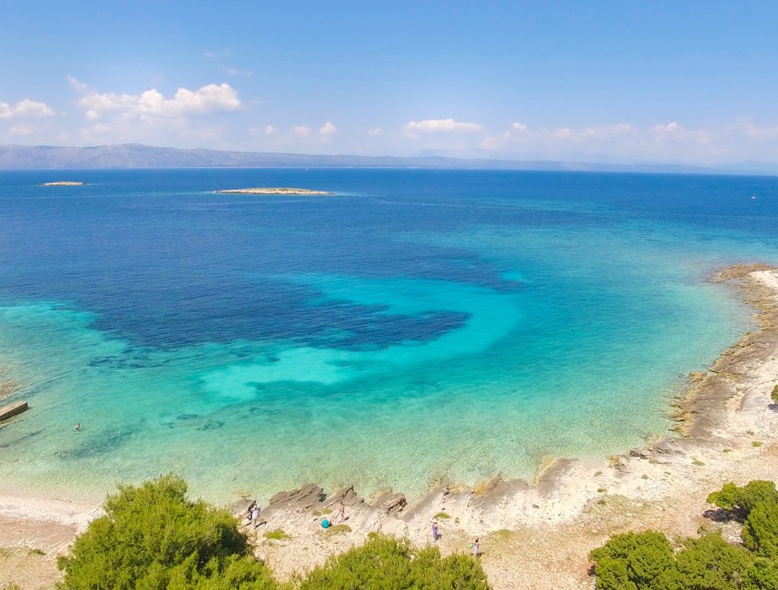 Breathtaking view of Proizd Beach featuring white sand, lush greenery, and turquoise Adriatic waters.