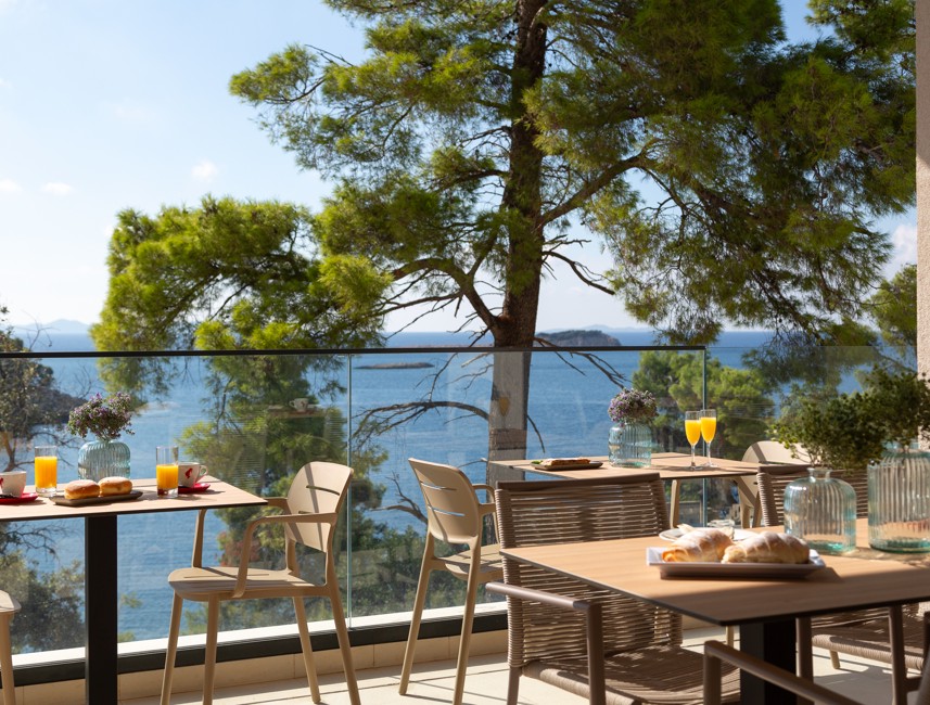 Frühstück auf der Terrasse eines Aminess Restaurants mit Meerblick, umgeben von Pinien und Morgenlicht