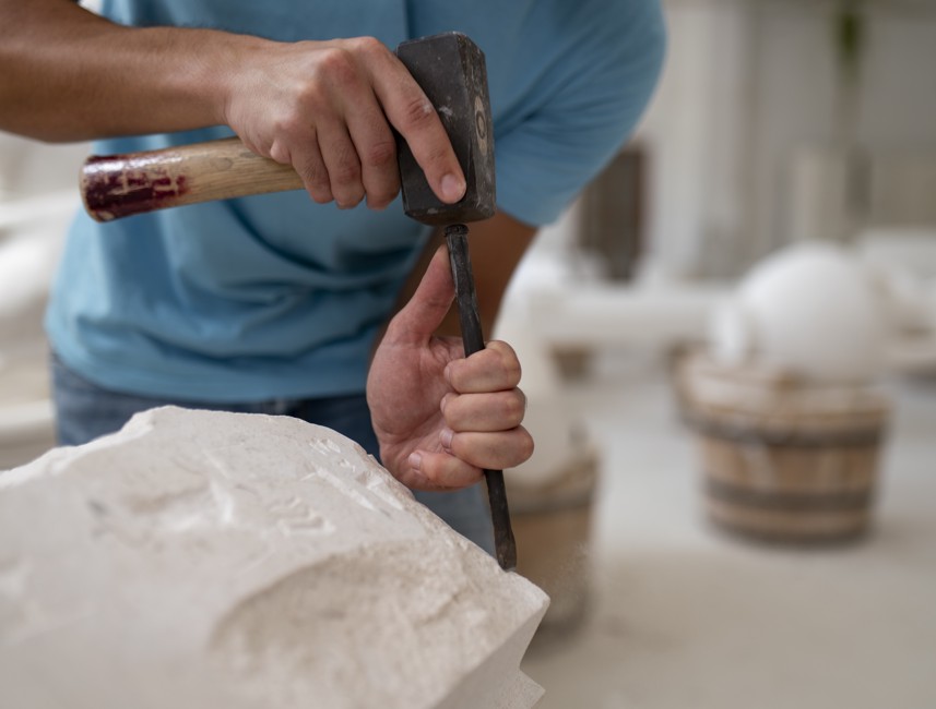 A man shaping stone with a chisel and hammer on Brač Island, Croatia, demonstrating the island’s traditional stone carving craft.