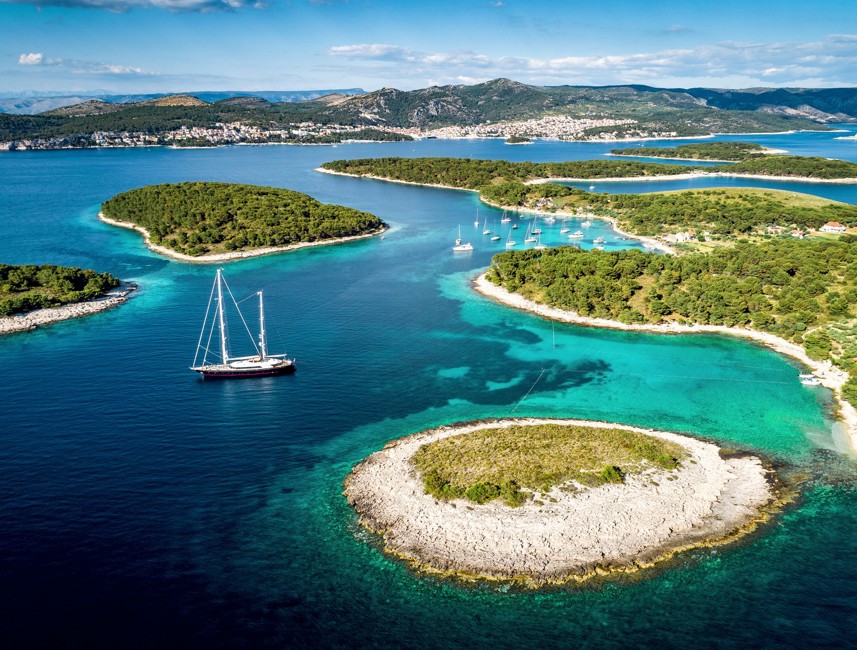 Vista aerea delle isole Pakleni vicino a Hvar con barca a vela e mare turchese.