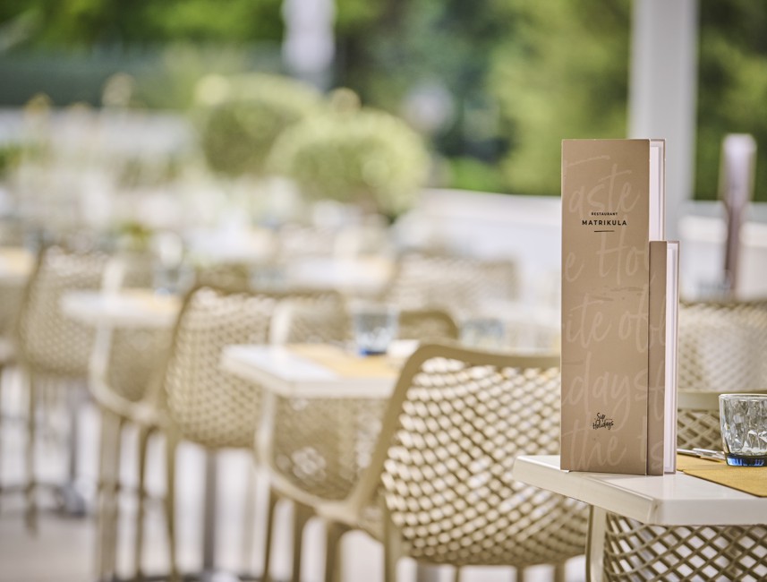 A modern table set with a menu of a la carte offer on the restaurant Matrikula terrace within the resort, near Port9 Planet Camping by Aminess.
