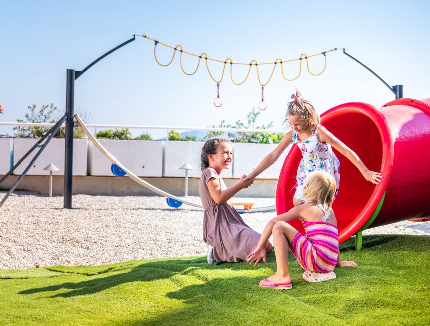 Kinder spielen auf dem Außenspielplatz des Aminess Veya Hotels Lišanj