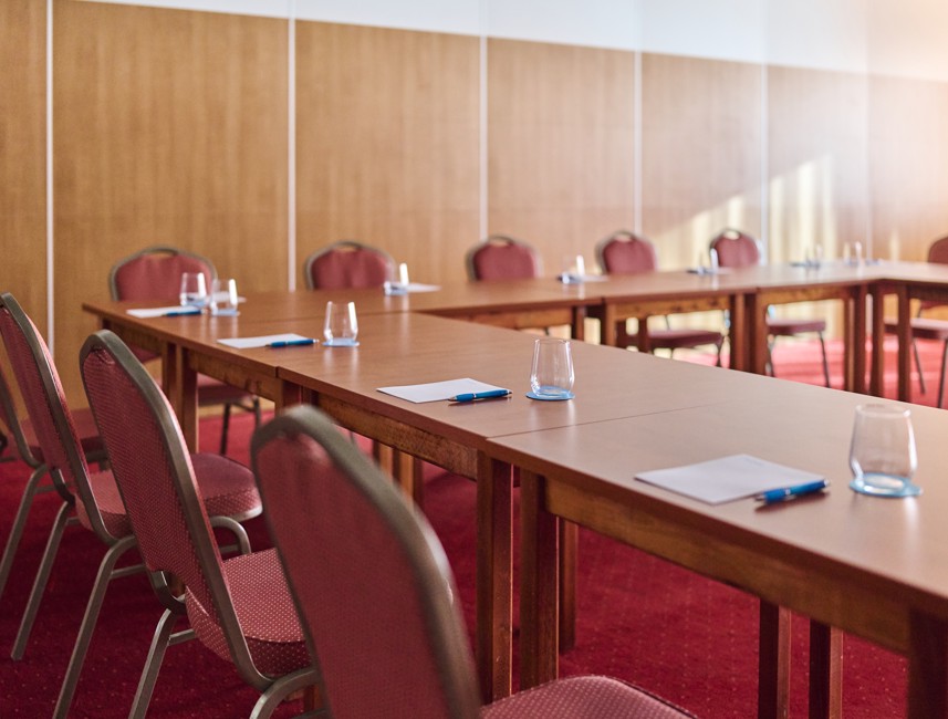 Configurazione del tavolo da riunione nella sala congressi presso l'Hotel Mediteran Maradiso di Aminess con bottiglie d'acqua e taccuini.