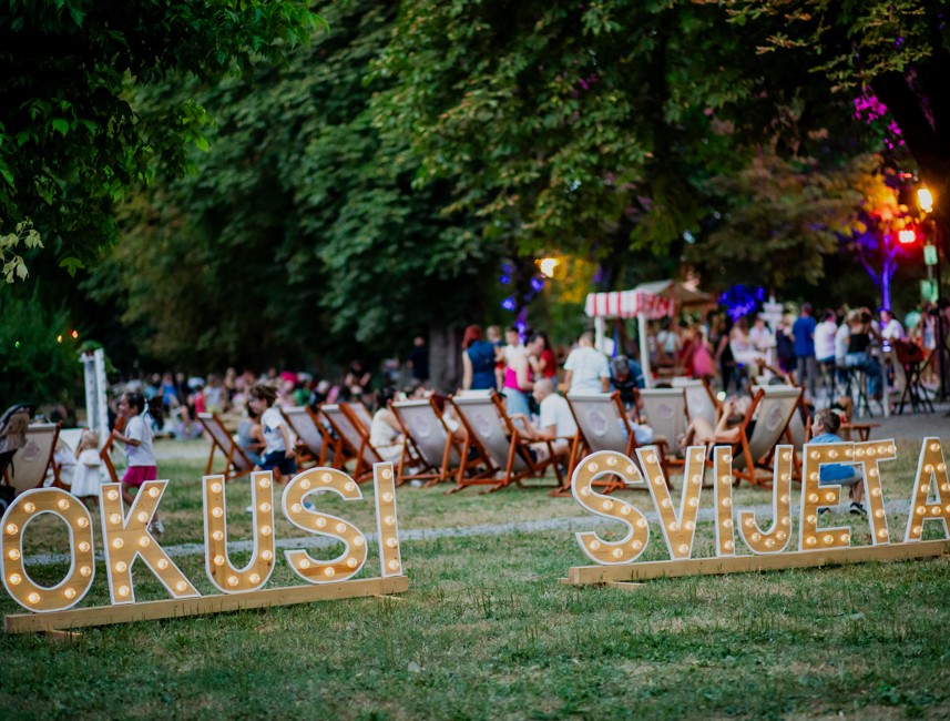 Bezoekers op het Okusi svijeta festival in Karlovac park met evenementbord foto Demjan Rozman
