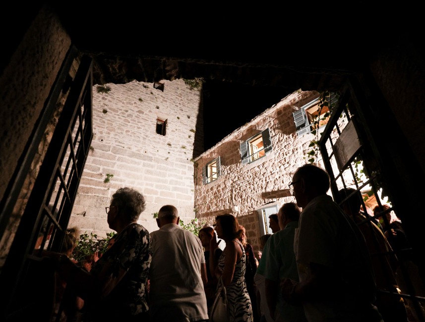 View from the museum doors on Brač Island, Croatia, looking towards a crowd of people and historic buildings, showcasing the island's cultural and architectural heritage.