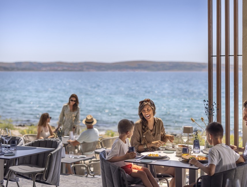 Family dining on a restaurant terrace with sea view at Avalona Resort