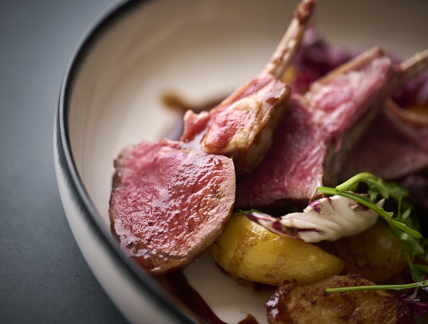 Aminess gastronomisch gerecht met lamskoteletten, aardappelen en verse groenten.