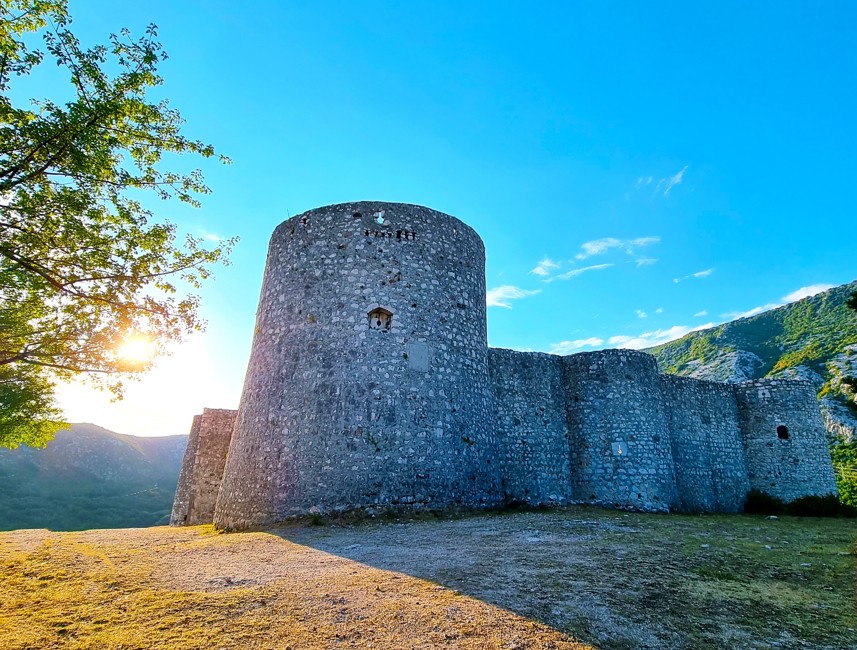 Historic Drivenik Castle near Crikvenica, surrounded by greenery and illuminated by morning sunlight.