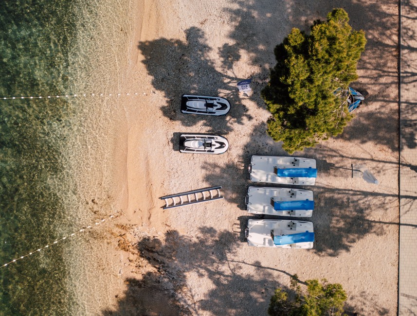 Luchtfoto van het strand en watersportgebied bij Aminess Avalona Camping Resort.