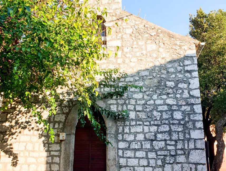 Holy Trinity Church in Novi Vinodolski, Croatia, featuring historic stone architecture and arched entrance.