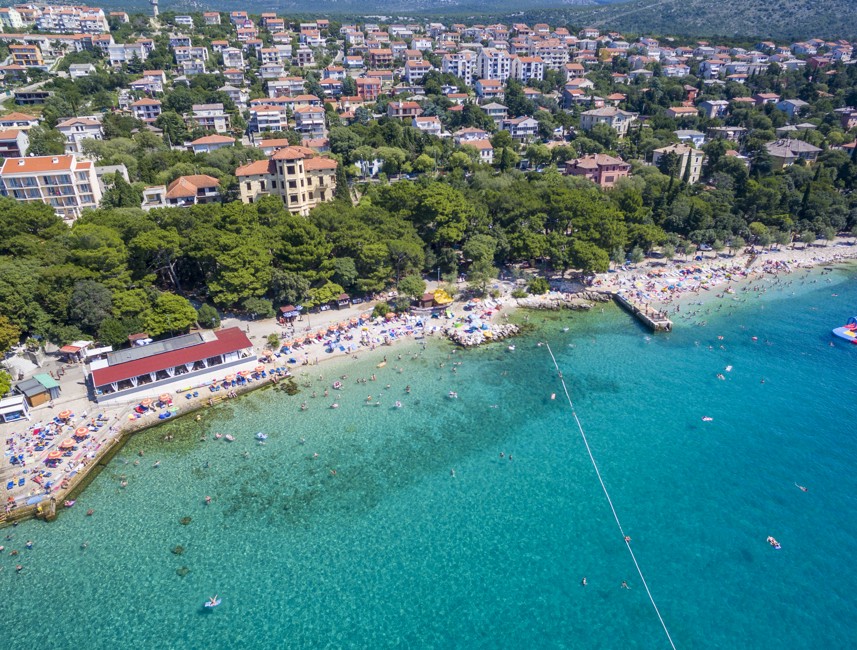 Aerial view of a beach with turquoise waters and coastal town in Novi Vinodolski, Croatia.