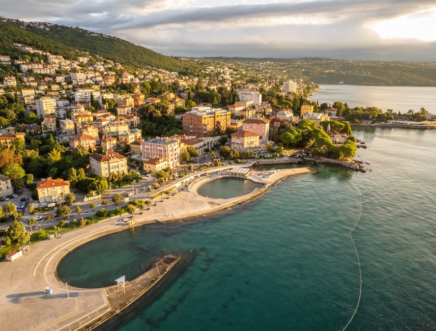 Aerial view of Opatija with historic villas, seaside promenade and the calm Kvarner Sea glowing in the warm light of sunset