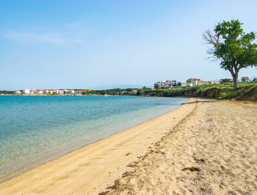 La spiaggia a Pag è un tranquillo rifugio, con le sue acque turchesi cristalline e le onde dolci, ideale per coloro che cercano un'esperienza di spiaggia pacifica.