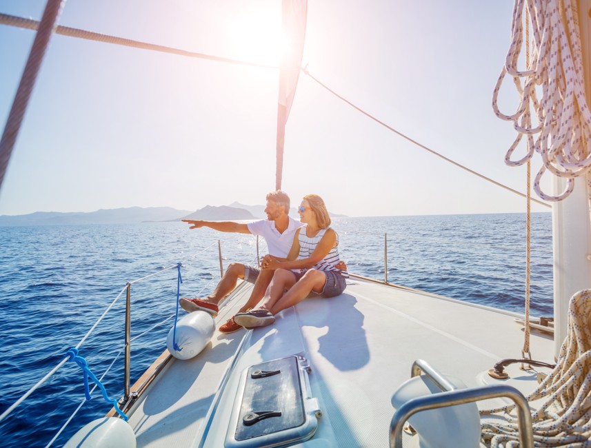 Couple enjoying a sunny day sailing on a yacht with the open sea in Crikvenica.