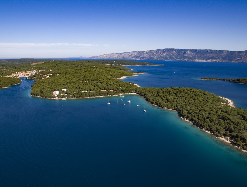 Sunny coastal landscape on Hvar Island, Croatia, featuring crystal-clear Adriatic waters, rugged cliffs, and lush Mediterranean vegetation – Aminess destination travel.