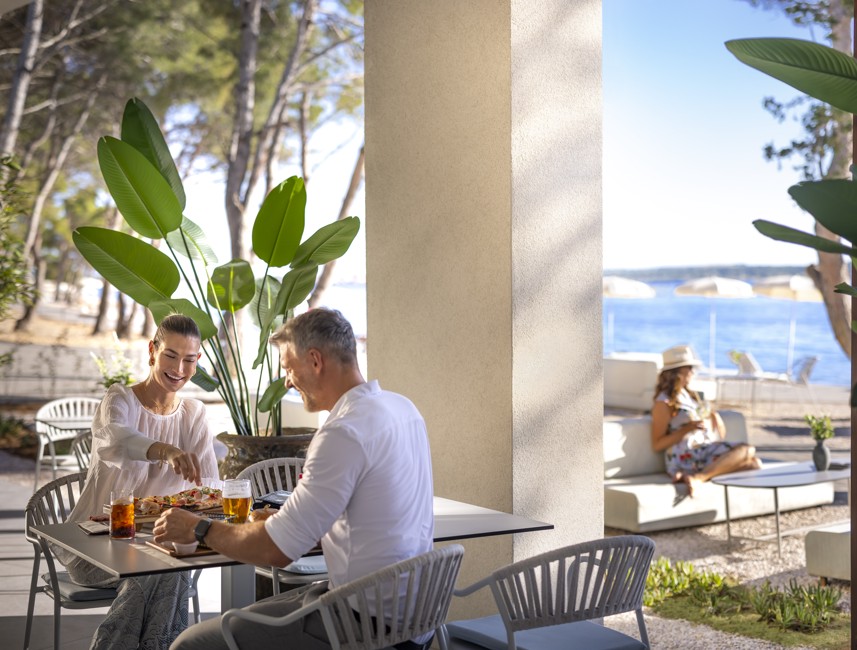 Couple enjoying a gourmet meal on a seaside terrace at Aminess Avalona Camping Resort