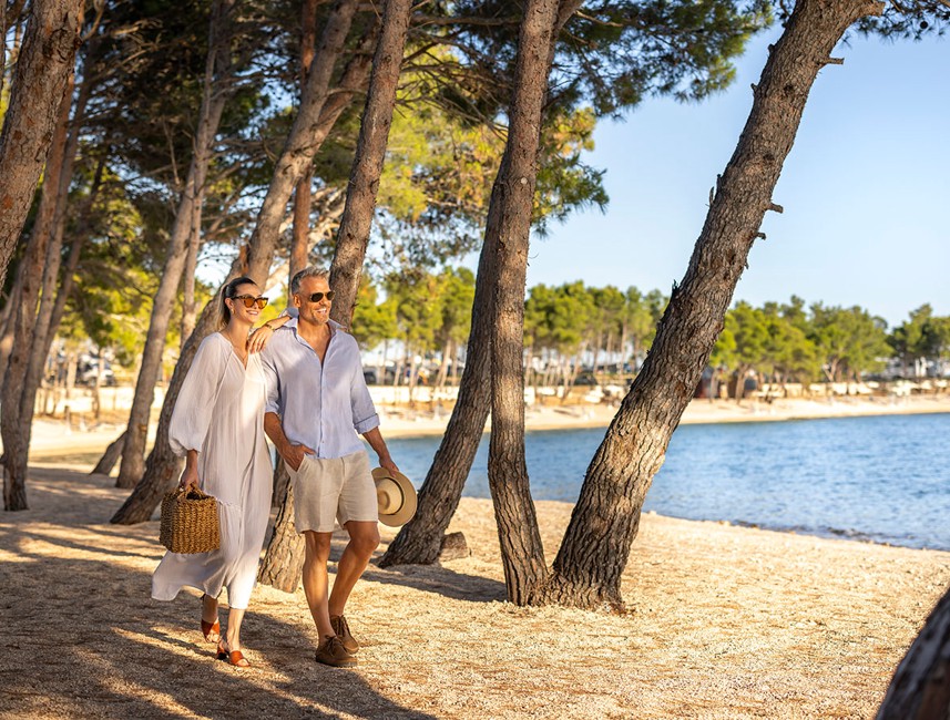 Paar spaziert am Strand im Aminess Style Camping Avalona Resort.