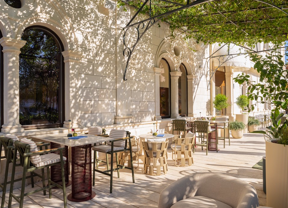 Terrazza del bar 7 Seas con tavoli eleganti e vegetazione mediterranea