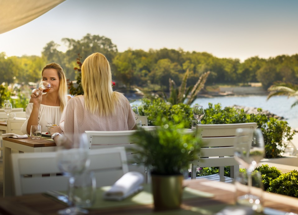 Frauen genießen ein Glas Wein in einem Restaurant im Aminess Planet Camping Maravea, Novigrad