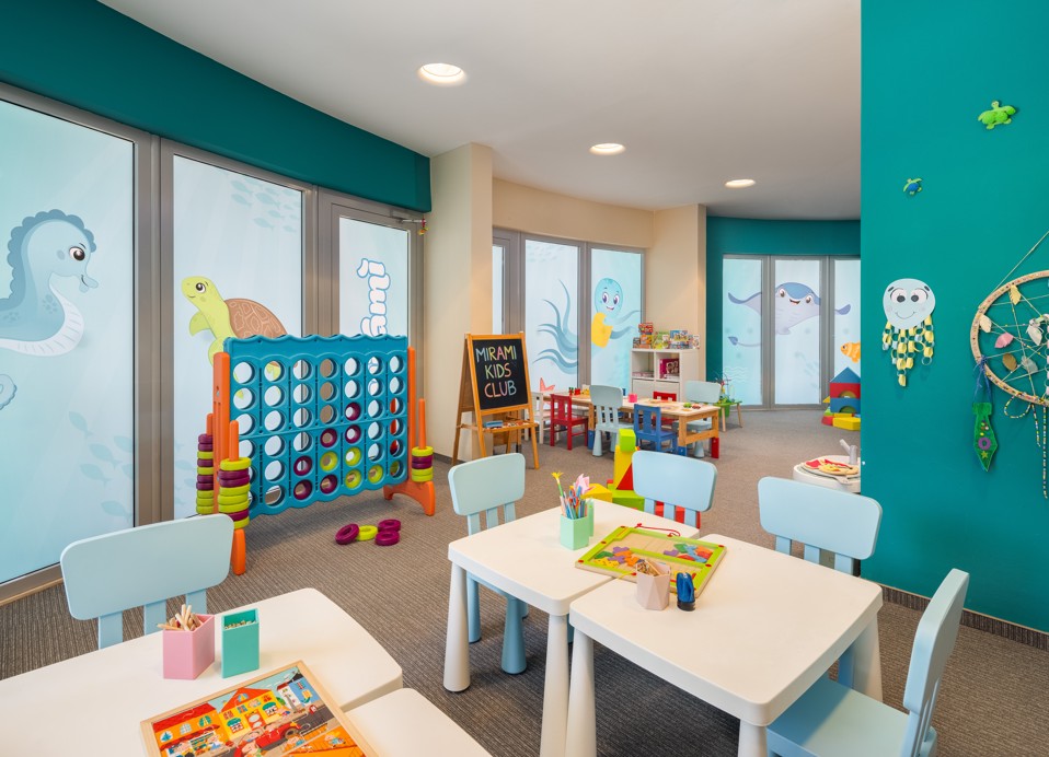 Buntes Miniclub-Spielzimmer im Aminess Vival Grand Azur Hotel mit Kindertischen und Spielzeug.