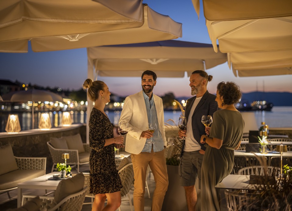 Prijatelji se zbirajo v lounge baru 7 Seas, uživajo v pijačah z razgledom blizu Aminess Style Camping Atea Resort.