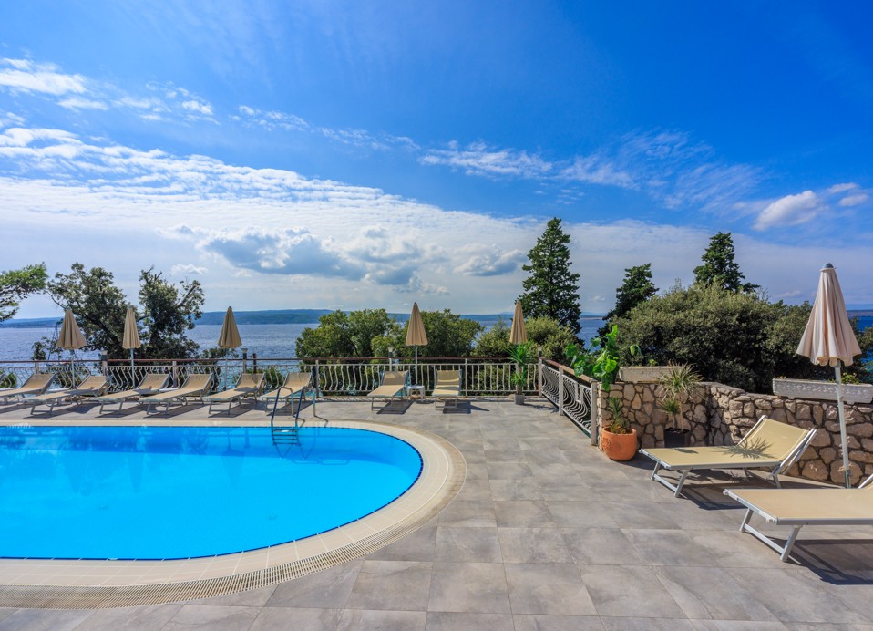 Piscina all'aperto presso l'Hotel Mediteran Maradiso di Aminess con vista sul mare e sulla vegetazione circostante.