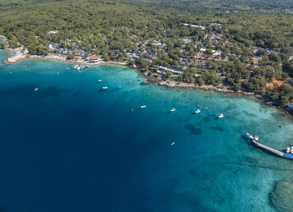 Panoramski zračni pogled na obalu i kuće za odmor okružene prirodnim ljepotama na otoku Krku u blizini Aminess Style Camping Atea Resorta.