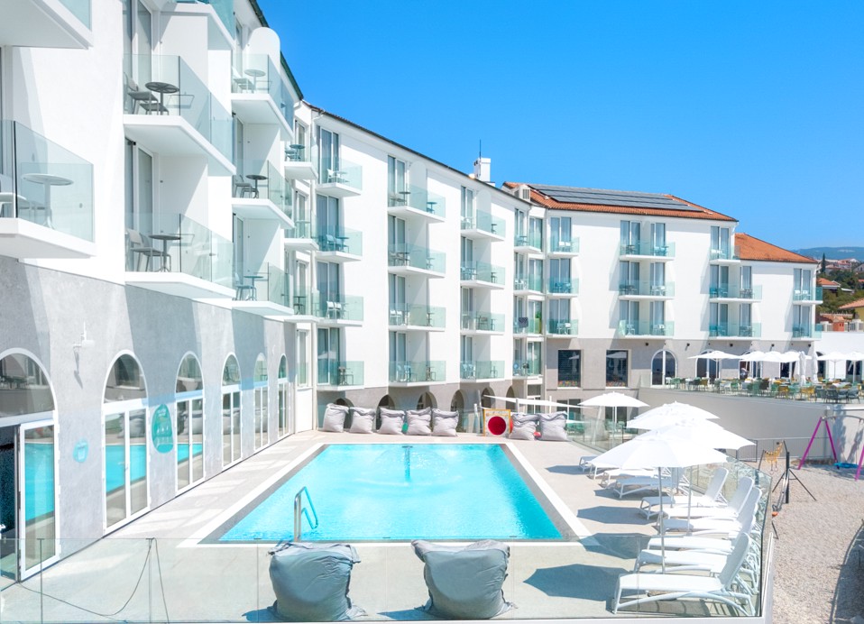 Aminess Vival Lišanj Family Hotel Blick auf den Poolbereich, der den Außenpool und die moderne Hotelarchitektur zeigt.