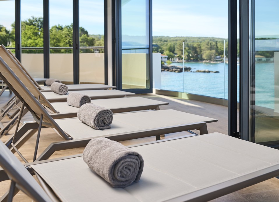 Comfortable spa lounge chairs with a view of the sea and serene surroundings at Aminess Style Camping Atea Resort.