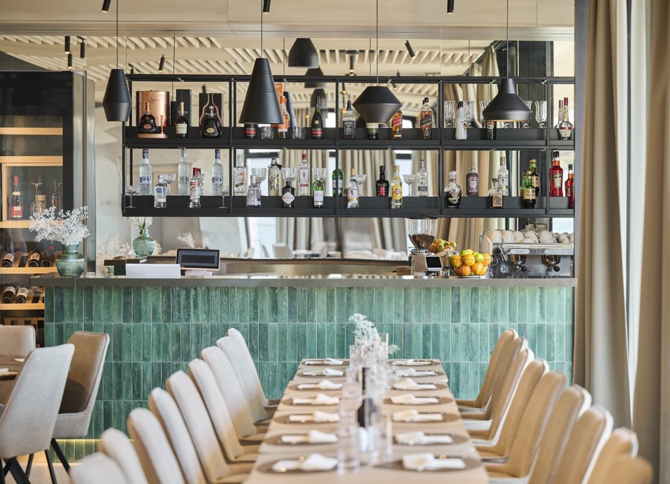 Wnętrze restauracji z barem i stołem w Aminess Florian & Godler Hotel.