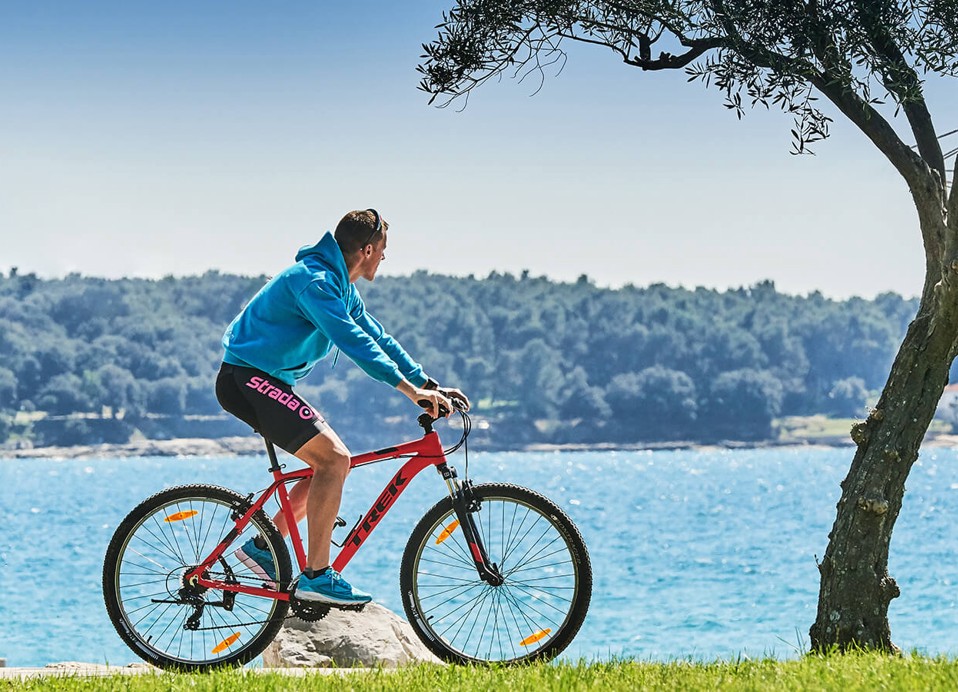 Eine lebendige Camping-Szene in Novigrad, mit Radfahrern am Meer, die Natur und Outdoor-Abenteuer präsentieren