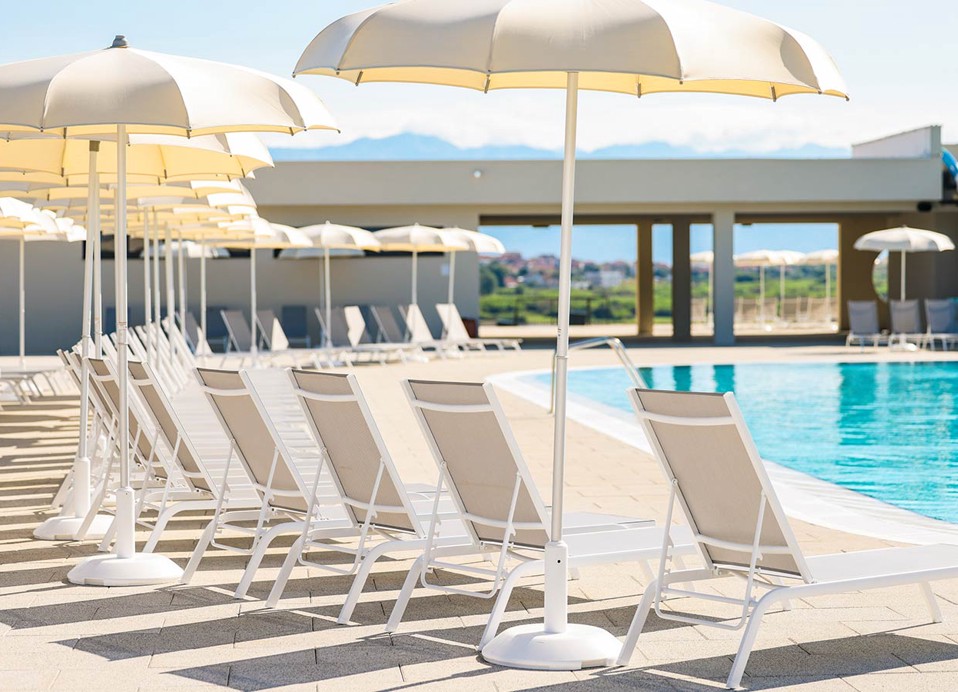 Ligstoelen en parasols bij het zwembad bij Aminess Style Camping Avalona resort.