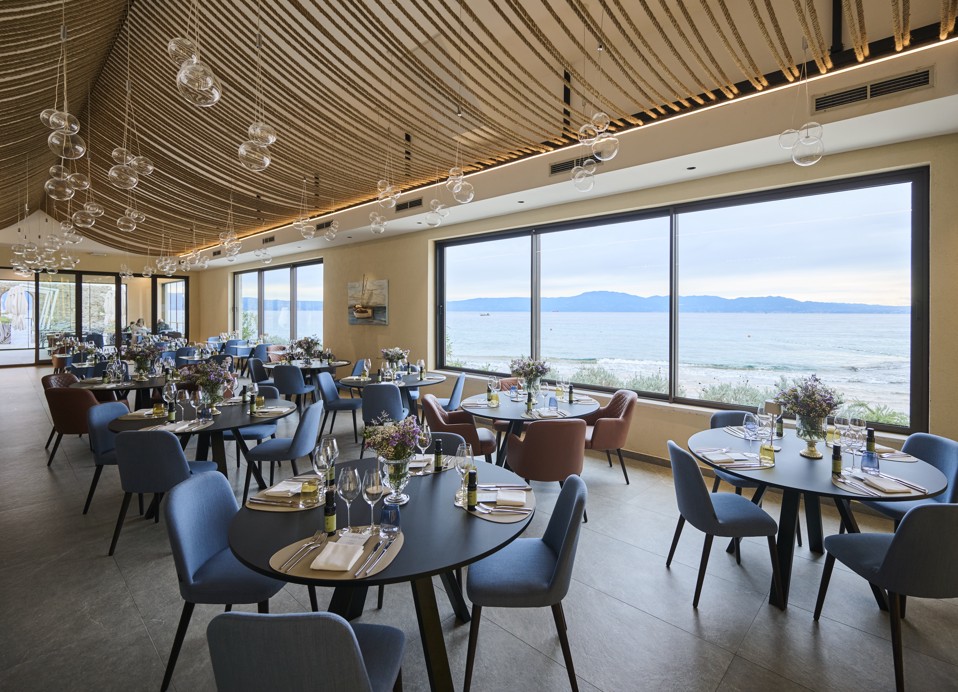 Elegantna jedilnica s panoramskimi okni in moderno dekoracijo v restavraciji in baru 7 Seas.