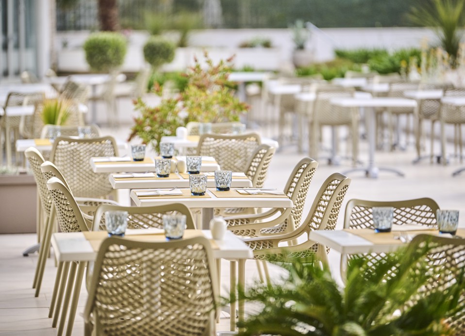 Ein Tisch, gedeckt mit Tellern, Besteck und Gläsern auf der Terrasse, mit einem wunderschönen Blick auf die Umgebung innerhalb des Resorts in der Nähe von Aminess Vival Port9 Residence.